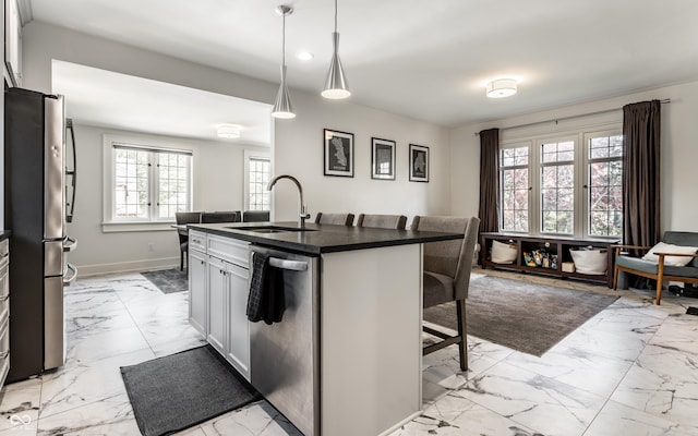 5124 N Capitol Ave, Indianapolis, IN 46208 - kitchen with marble finish floor, dark countertops, a kitchen breakfast bar, a sink, and stainless steel appliances