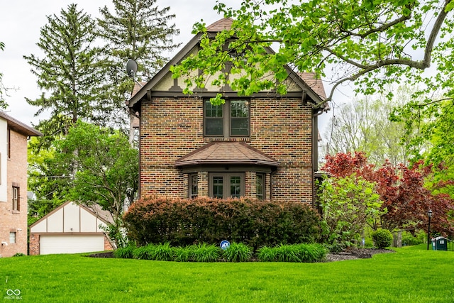 5124 N Capitol Ave, Indianapolis, IN 46208 - view of front facade with a detached garage, an outbuilding, a front yard, and brick siding