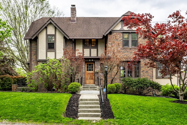 5124 N Capitol Ave, Indianapolis, IN 46208 - tudor house featuring a chimney, brick siding, stucco siding, and a front yard