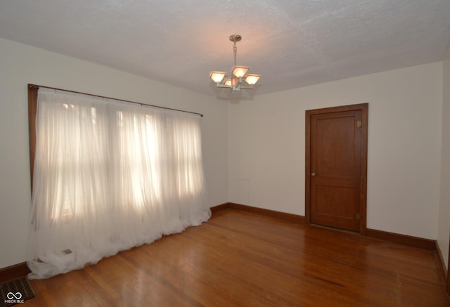 6051 Lowell Ave, Indianapolis, IN 46219 - empty room with light wood-style floors and a chandelier