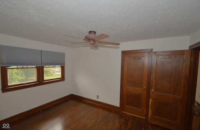 6051 Lowell Ave, Indianapolis, IN 46219 - unfurnished bedroom with dark wood-style floors, a textured ceiling, and ceiling fan
