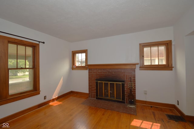 6051 Lowell Ave, Indianapolis, IN 46219 - unfurnished living room with wood finished floors and a fireplace