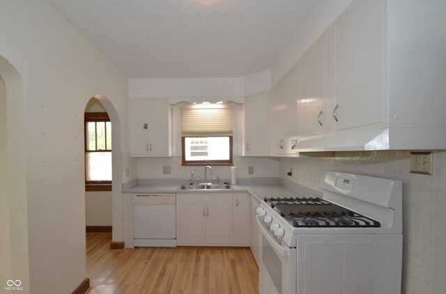 6051 Lowell Ave, Indianapolis, IN 46219 - kitchen featuring white appliances, arched walkways, under cabinet range hood, light wood-style floors, and white cabinets