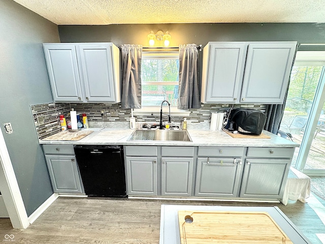 4223 Kestrel Ct, Indianapolis, IN 46254 - kitchen featuring a sink, light wood-style flooring, black dishwasher, decorative backsplash, and gray cabinetry
