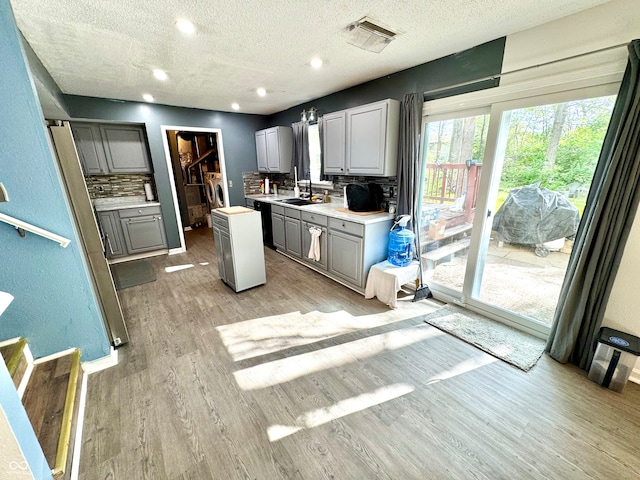 4223 Kestrel Ct, Indianapolis, IN 46254 - kitchen with a textured ceiling, gray cabinetry, decorative backsplash, and light wood-style floors