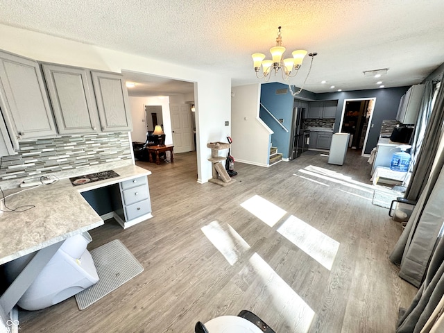 4223 Kestrel Ct, Indianapolis, IN 46254 - dining room with stairs, baseboards, a textured ceiling, light wood-style flooring, and a notable chandelier