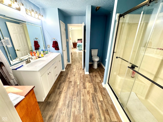 4223 Kestrel Ct, Indianapolis, IN 46254 - full bathroom with vanity, wood finished floors, toilet, a textured ceiling, and a shower stall