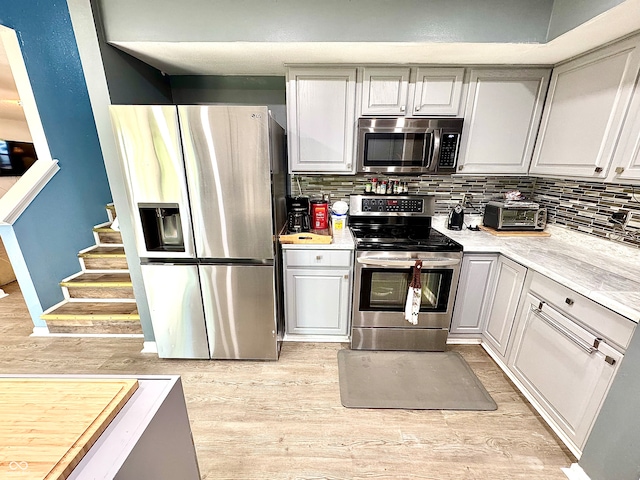 4223 Kestrel Ct, Indianapolis, IN 46254 - kitchen featuring appliances with stainless steel finishes, backsplash, and light wood finished floors