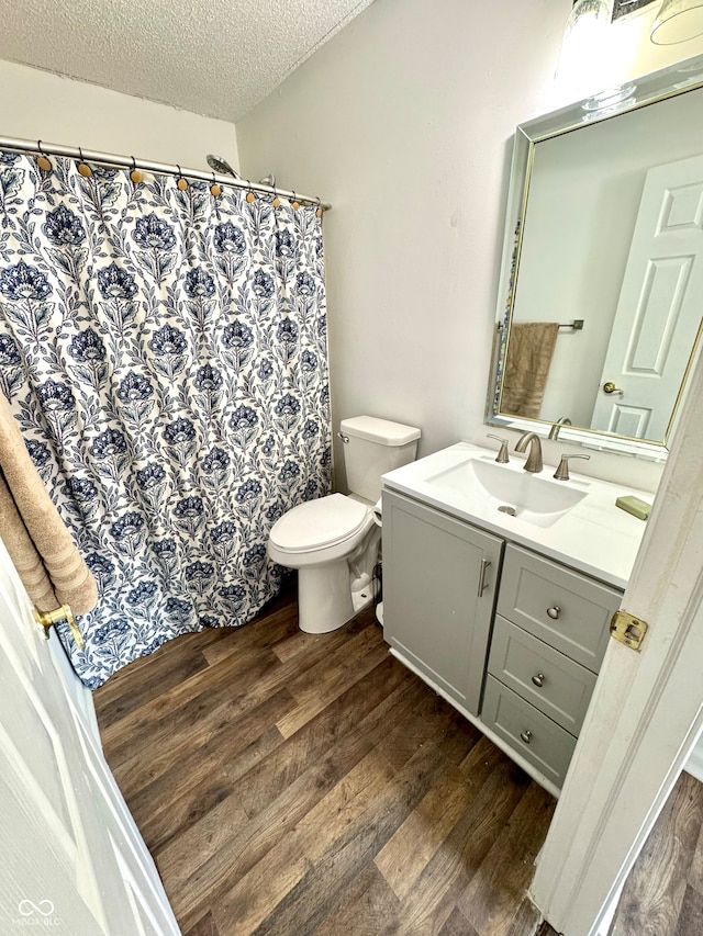 4223 Kestrel Ct, Indianapolis, IN 46254 - full bathroom with a textured ceiling, vanity, toilet, and wood finished floors