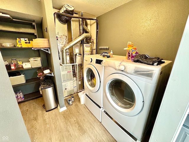 4223 Kestrel Ct, Indianapolis, IN 46254 - washroom featuring laundry area, a textured ceiling, a textured wall, light wood-style flooring, and washer and clothes dryer