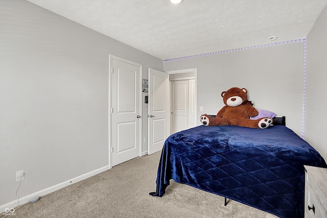bedroom with baseboards, carpet flooring, and a textured ceiling