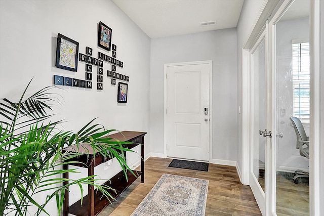 entryway featuring french doors, baseboards, visible vents, and wood finished floors