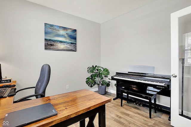 home office featuring baseboards and light wood finished floors