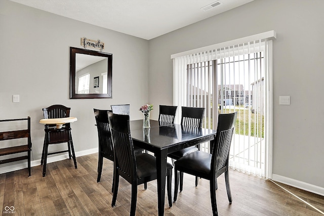 dining space featuring baseboards, wood finished floors, and visible vents