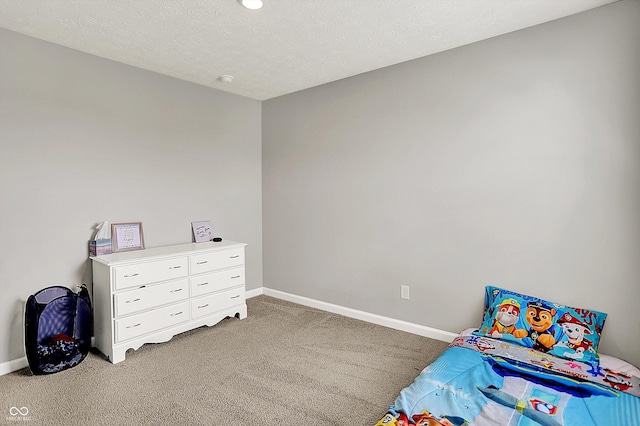 bedroom featuring a textured ceiling, baseboards, and light colored carpet