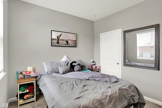 bedroom with baseboards and carpet
