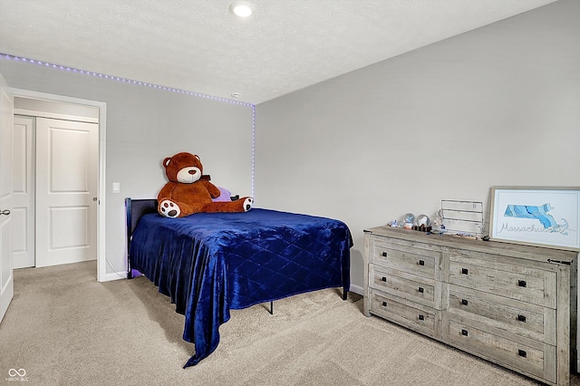 carpeted bedroom featuring baseboards and a textured ceiling