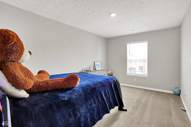 carpeted bedroom featuring a textured ceiling and baseboards