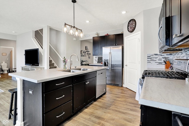 kitchen featuring light countertops, a sink, an island with sink, and stainless steel appliances