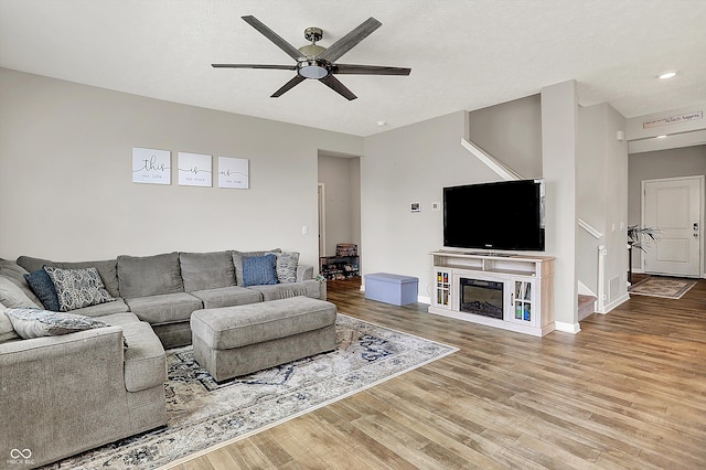 living room featuring a ceiling fan, baseboards, recessed lighting, wood finished floors, and visible vents