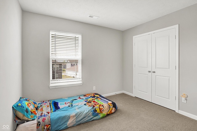 bedroom featuring baseboards, multiple windows, carpet, and a closet