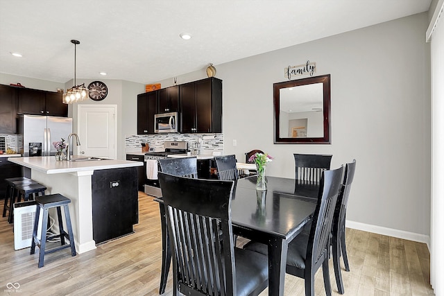 dining area featuring light wood-type flooring, recessed lighting, and baseboards