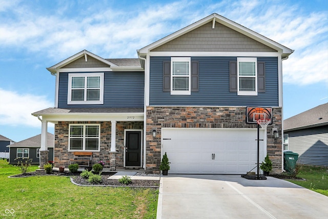 craftsman-style house with a front yard, driveway, stone siding, and a garage