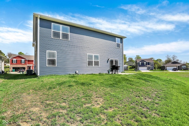 rear view of house with a lawn and central AC