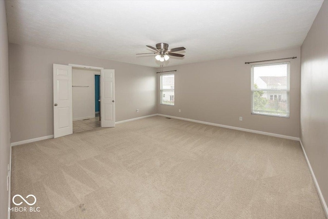 2006 Creek Bank Dr, Columbus, IN 47201 - spare room featuring a ceiling fan, light colored carpet, and baseboards
