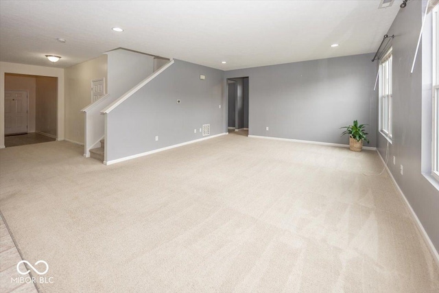 2006 Creek Bank Dr, Columbus, IN 47201 - unfurnished living room featuring stairway, baseboards, light colored carpet, and recessed lighting