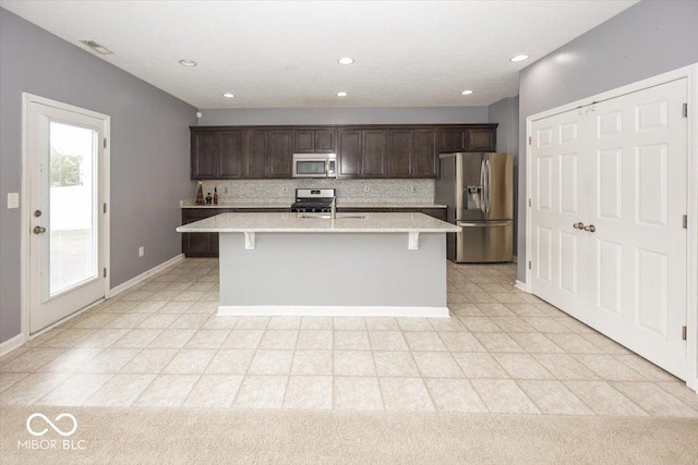 2006 Creek Bank Dr, Columbus, IN 47201 - kitchen featuring stainless steel appliances, dark brown cabinetry, a center island with sink, backsplash, and recessed lighting