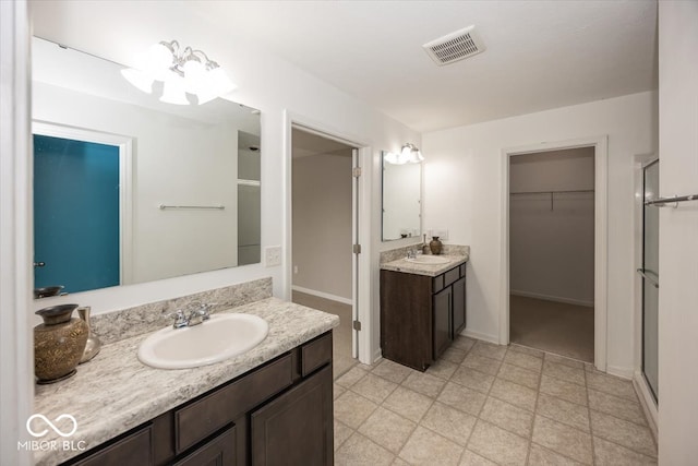 2006 Creek Bank Dr, Columbus, IN 47201 - full bathroom featuring a walk in closet, a shower stall, two vanities, and baseboards