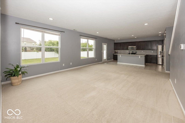 2006 Creek Bank Dr, Columbus, IN 47201 - unfurnished living room with light colored carpet, baseboards, and recessed lighting