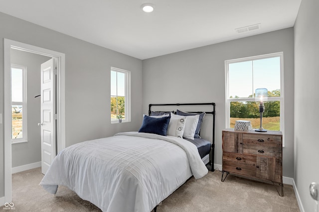 bedroom featuring light colored carpet, baseboards, and visible vents