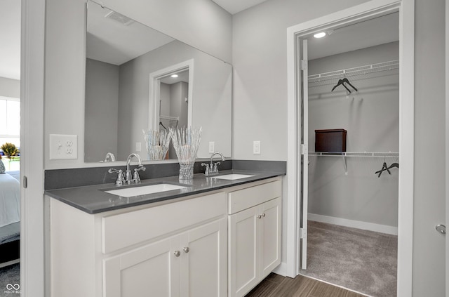 bathroom featuring double vanity, visible vents, a sink, and ensuite bath
