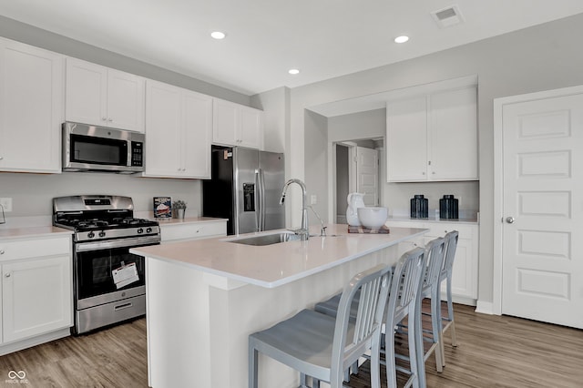 kitchen featuring light wood-style floors, appliances with stainless steel finishes, light countertops, and visible vents
