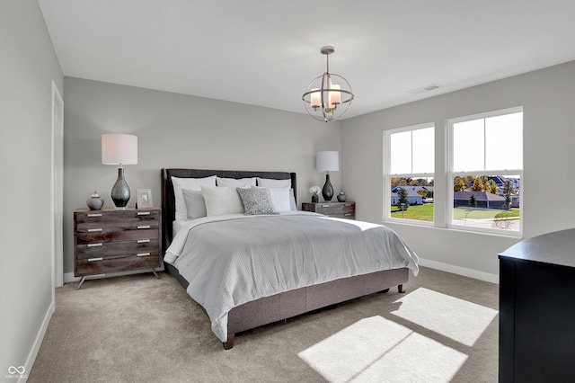 carpeted bedroom with an inviting chandelier, baseboards, and visible vents