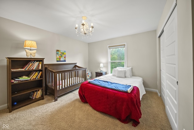 carpeted bedroom featuring baseboards and a notable chandelier