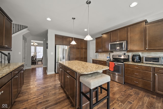 kitchen with stainless steel appliances, a center island, tasteful backsplash, and a toaster