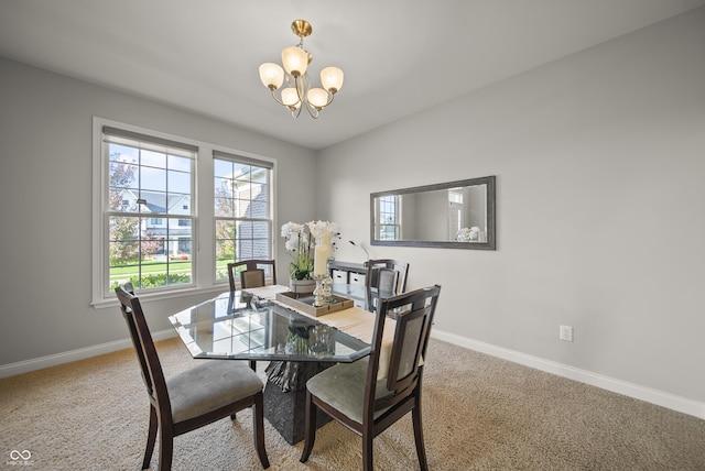 carpeted dining room with an inviting chandelier and baseboards