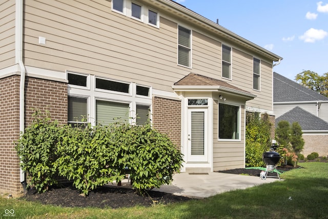 view of front facade with brick siding and a front lawn