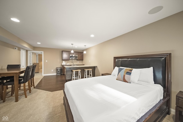 bedroom featuring a sink, recessed lighting, baseboards, wet bar, and wood finished floors