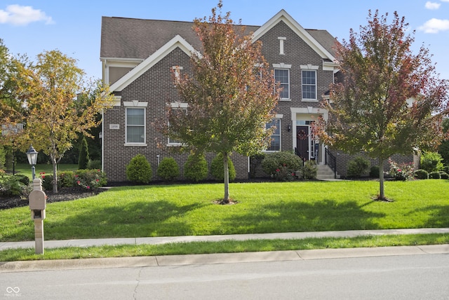 view of front of home featuring brick siding and a front yard