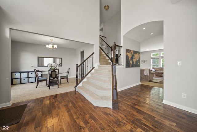 foyer entrance featuring wood-type flooring, baseboards, stairway, recessed lighting, and arched walkways