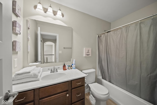 bathroom featuring vanity, shower / bath combo with shower curtain, and toilet