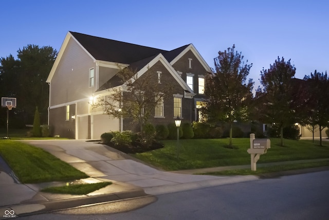 traditional home with a garage, concrete driveway, and a front lawn
