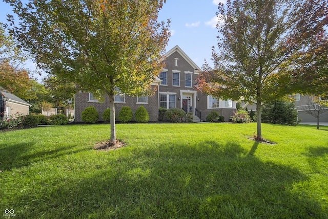 obstructed view of property featuring a front lawn and brick siding