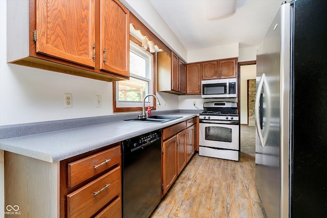 403 Hawthorn Dr, Crawfordsville, IN 47933 - kitchen featuring brown cabinetry, light wood-type flooring, a sink, light countertops, and stainless steel appliances
