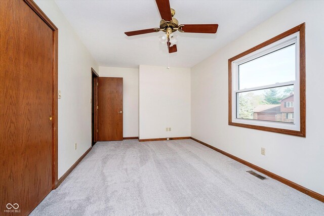 403 Hawthorn Dr, Crawfordsville, IN 47933 - empty room with visible vents, baseboards, ceiling fan, and light colored carpet