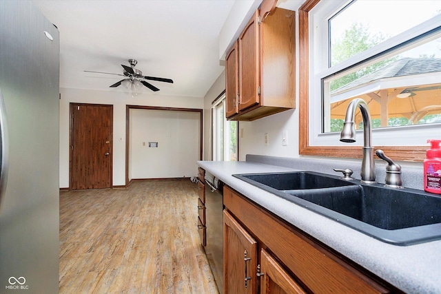 403 Hawthorn Dr, Crawfordsville, IN 47933 - kitchen featuring brown cabinetry, dishwasher, a sink, light countertops, and light wood finished floors